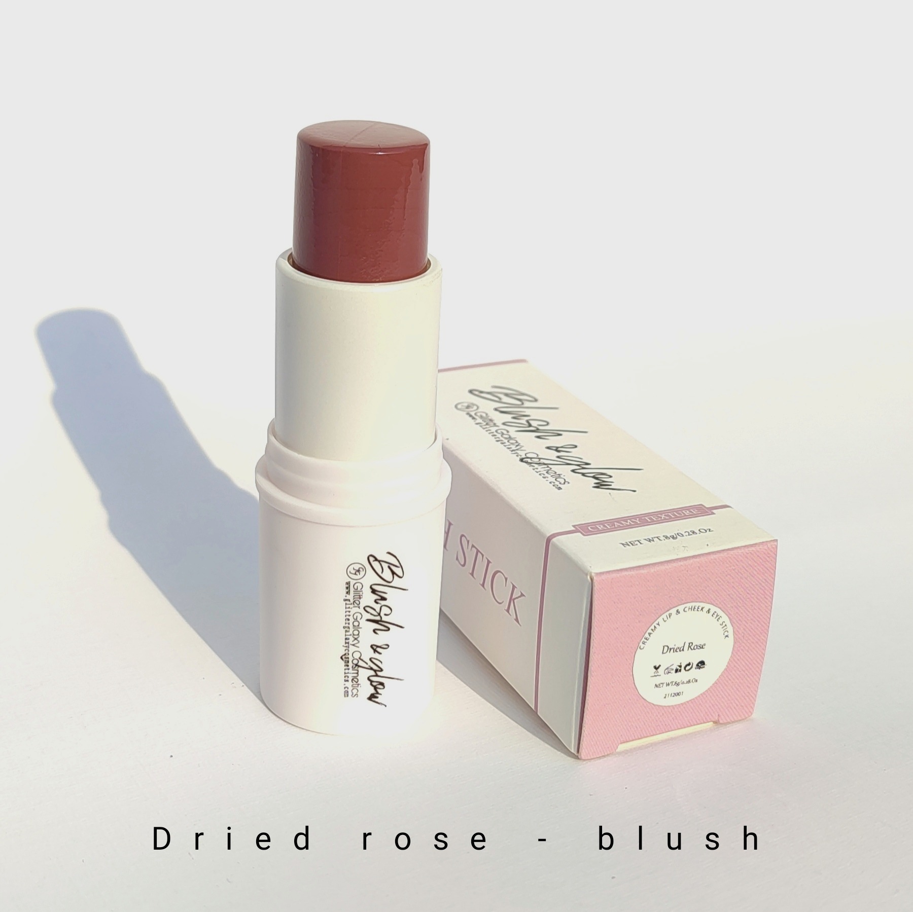 Glitter Galaxy Cosmetics Dried Rose Blush Stick featuring a creamy dusty rose blush in a twist-up stick with elegant pastel pink packaging for a soft natural glow.