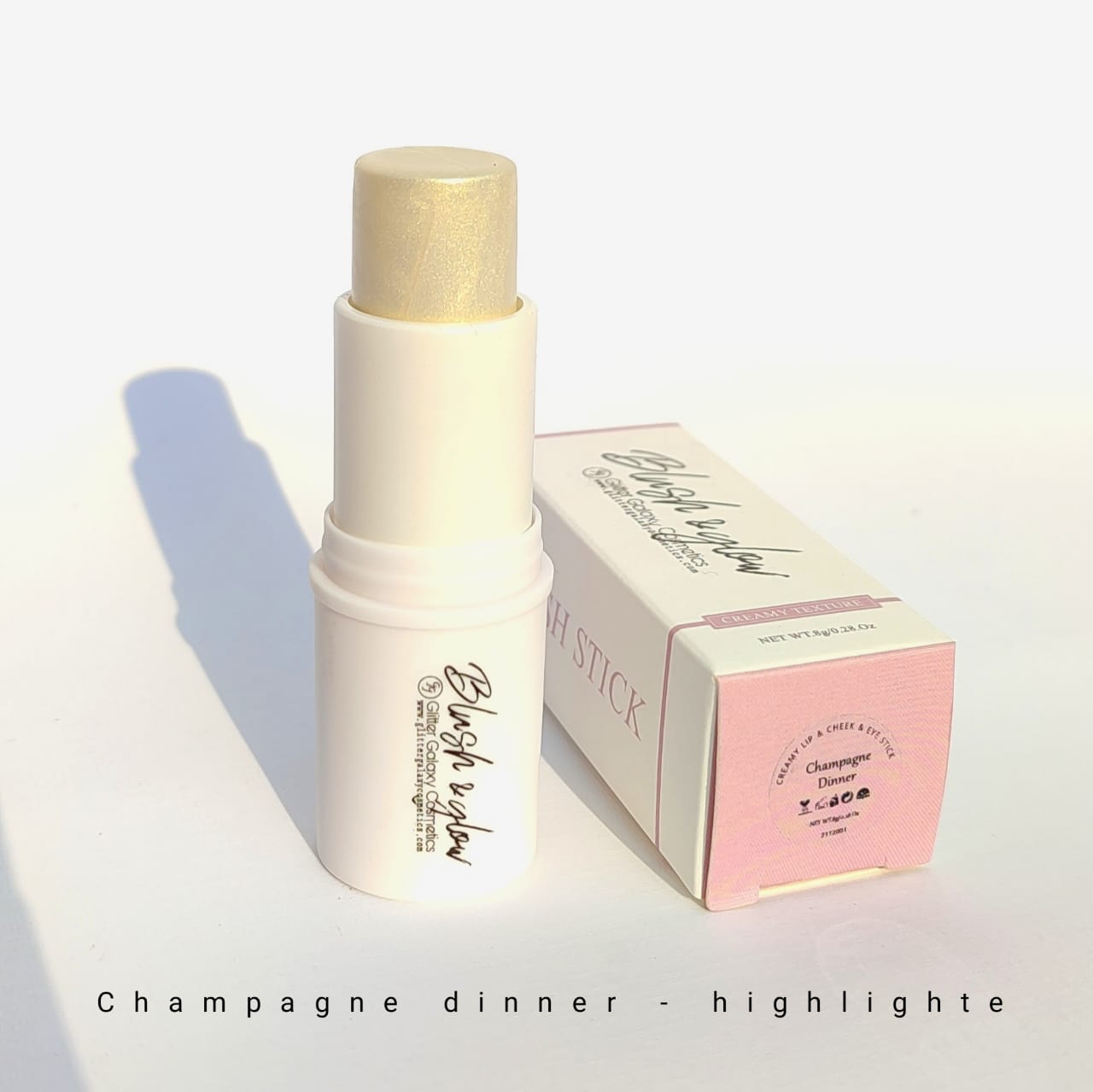 Glitter Galaxy Cosmetics Champagne Dinner Highlighter Stick featuring a creamy champagne gold highlighter in a twist-up stick with elegant matte packaging for radiant glowing makeup.