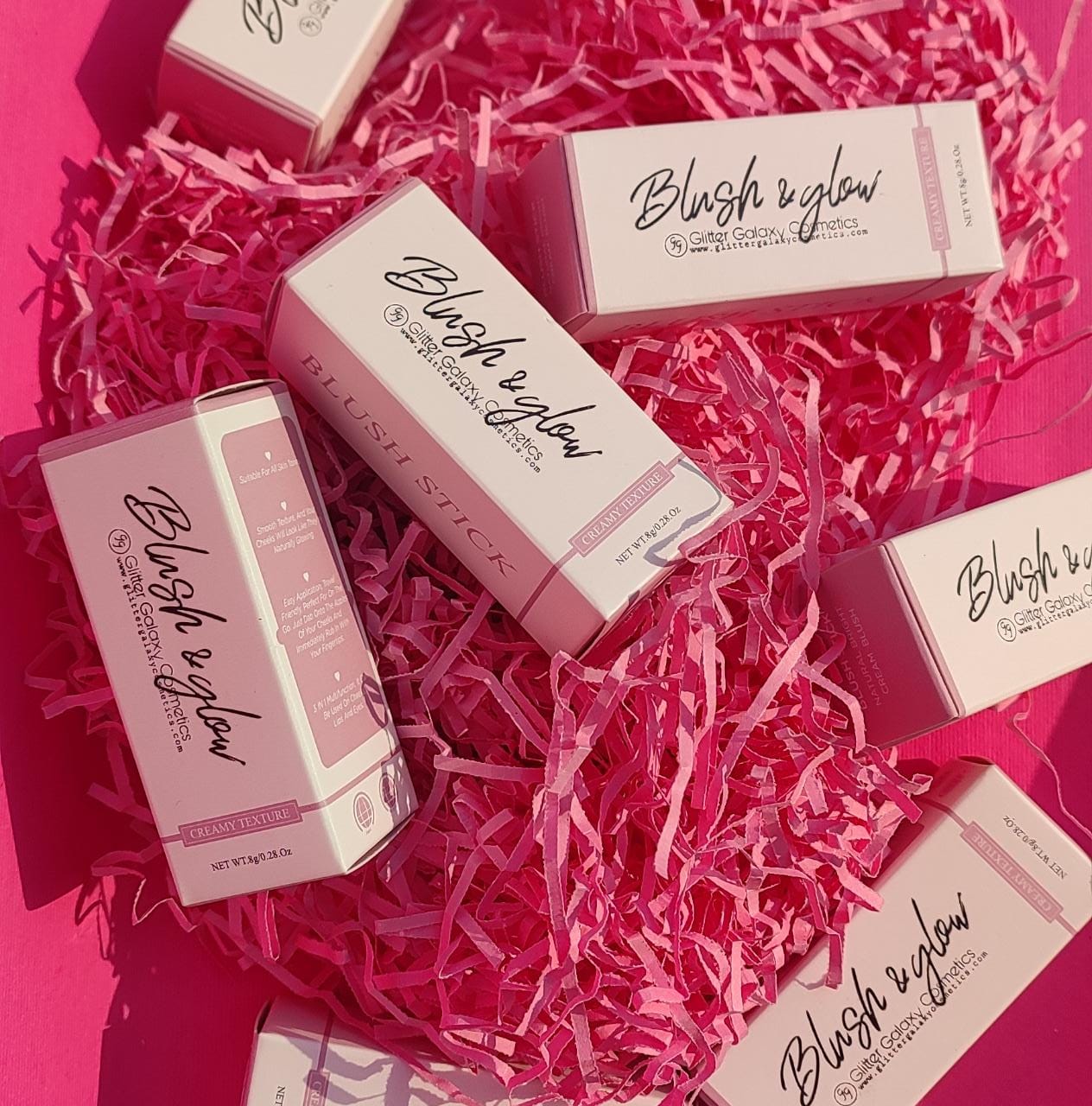 Glitter Galaxy Cosmetics Blush & Glow collection featuring premium cream blush sticks and champagne highlighter sticks in elegant pastel pink packaging displayed in a gift box.