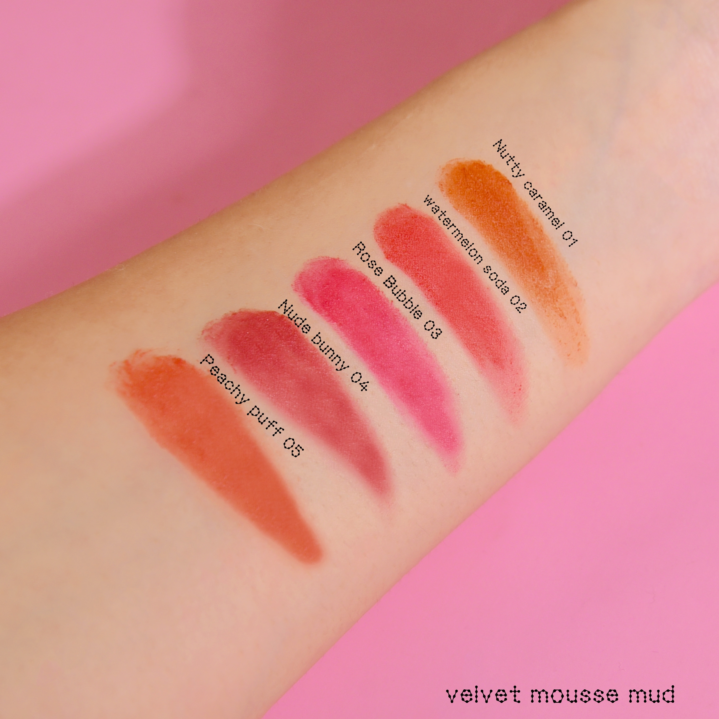arm swatches of glitter galaxy velvet mousse mud lip and cheek tint featuring nutty caramel 01, watermelon soda 02, rose bubble 03, nude bunny 04, and peachy puff 05.